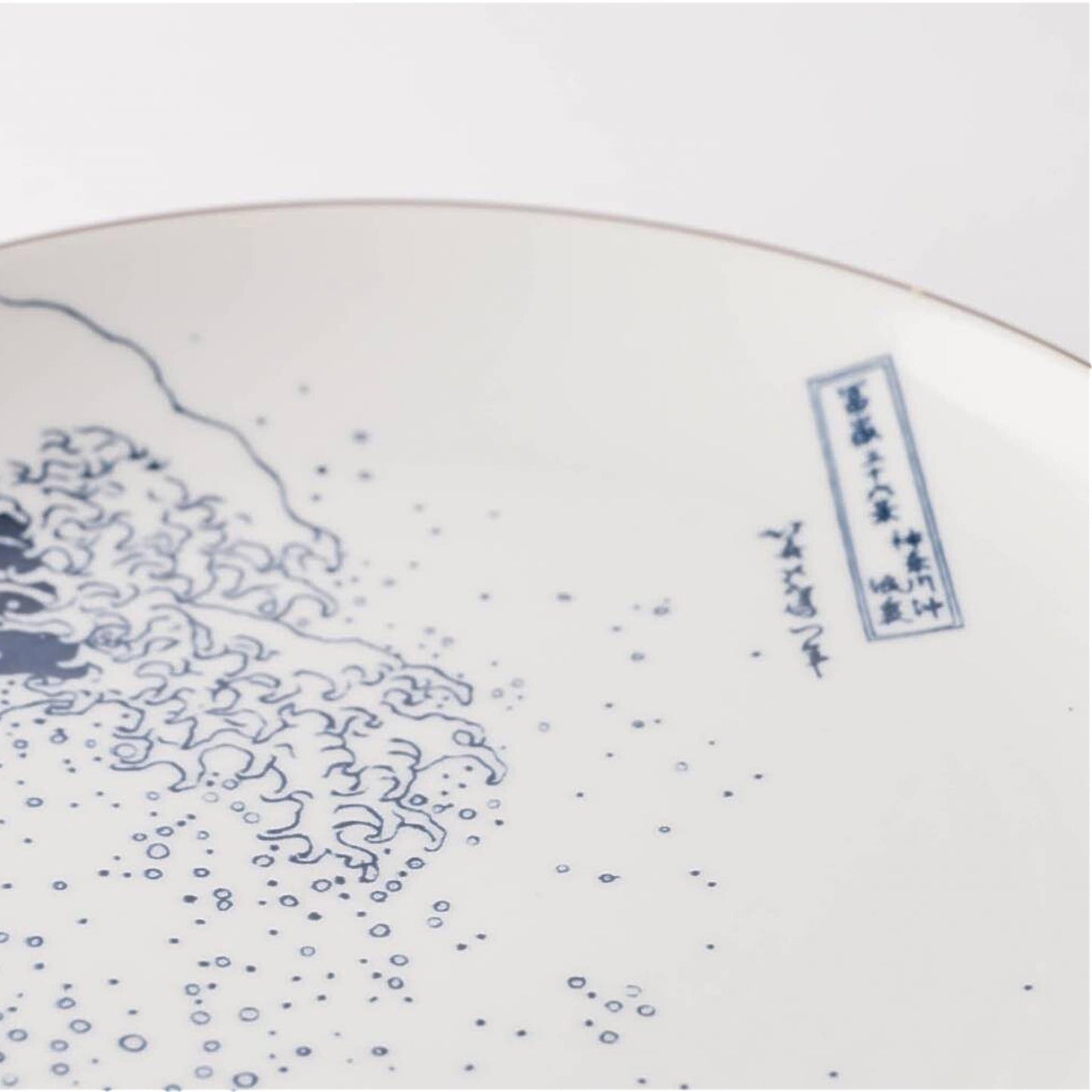 Ceramic plate with blue wave design and text on a white background