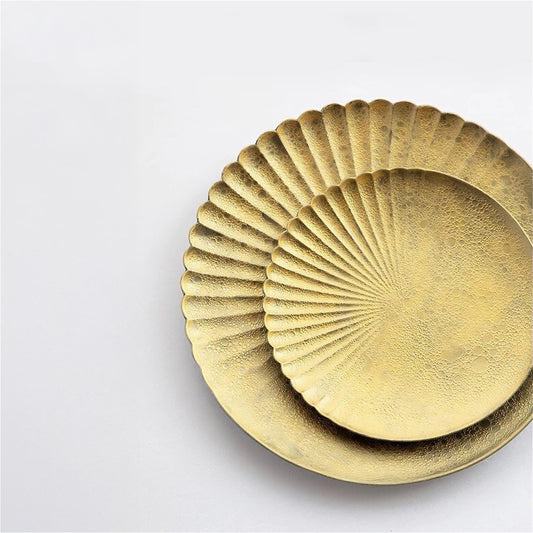 Set of gold decorative plates on a light gray background