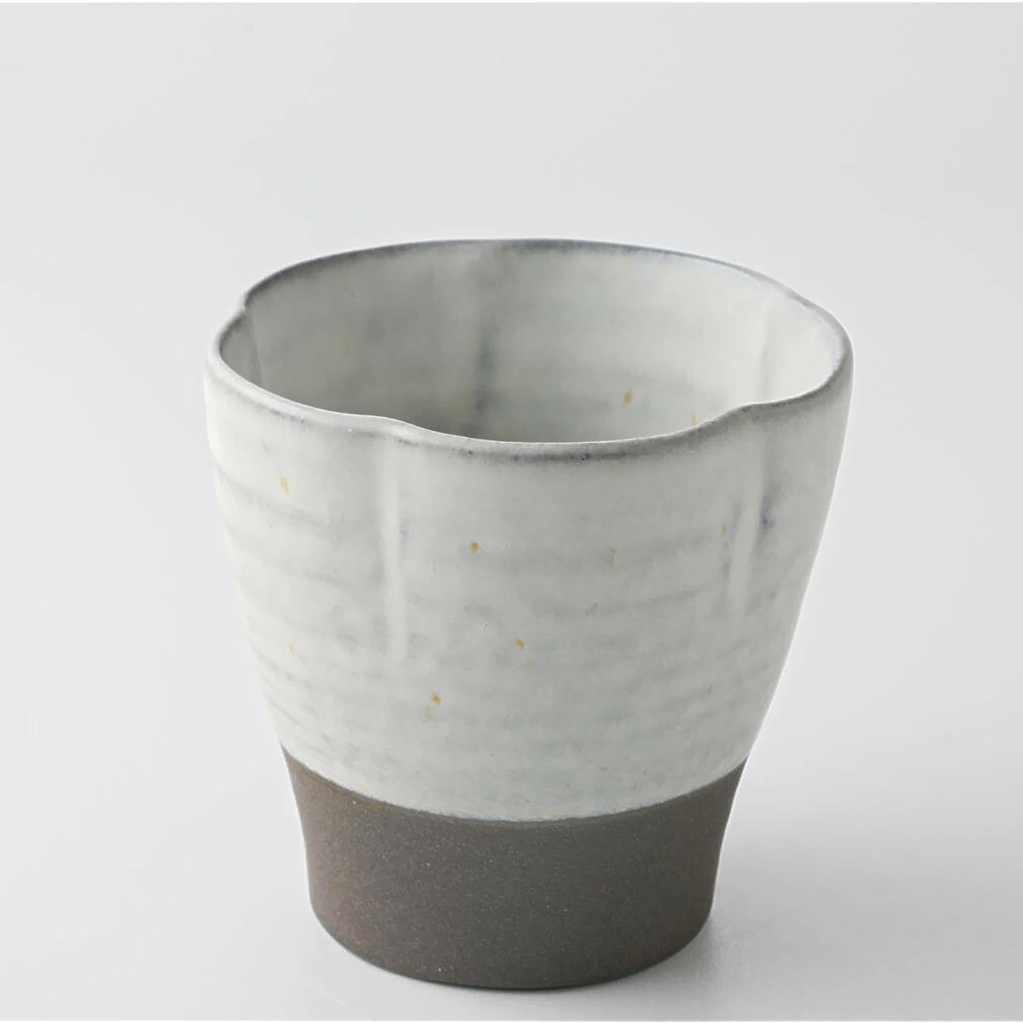 Ceramic cup with two-tone design on a light gray background