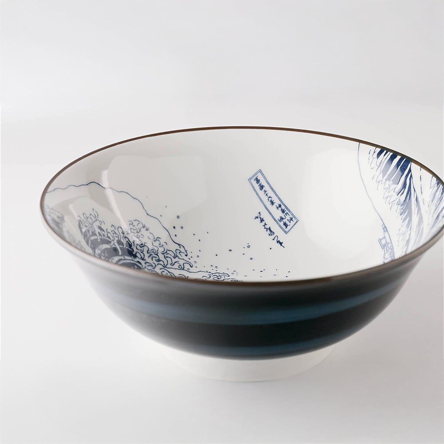 Ceramic bowl with blue wave design and text on a white background