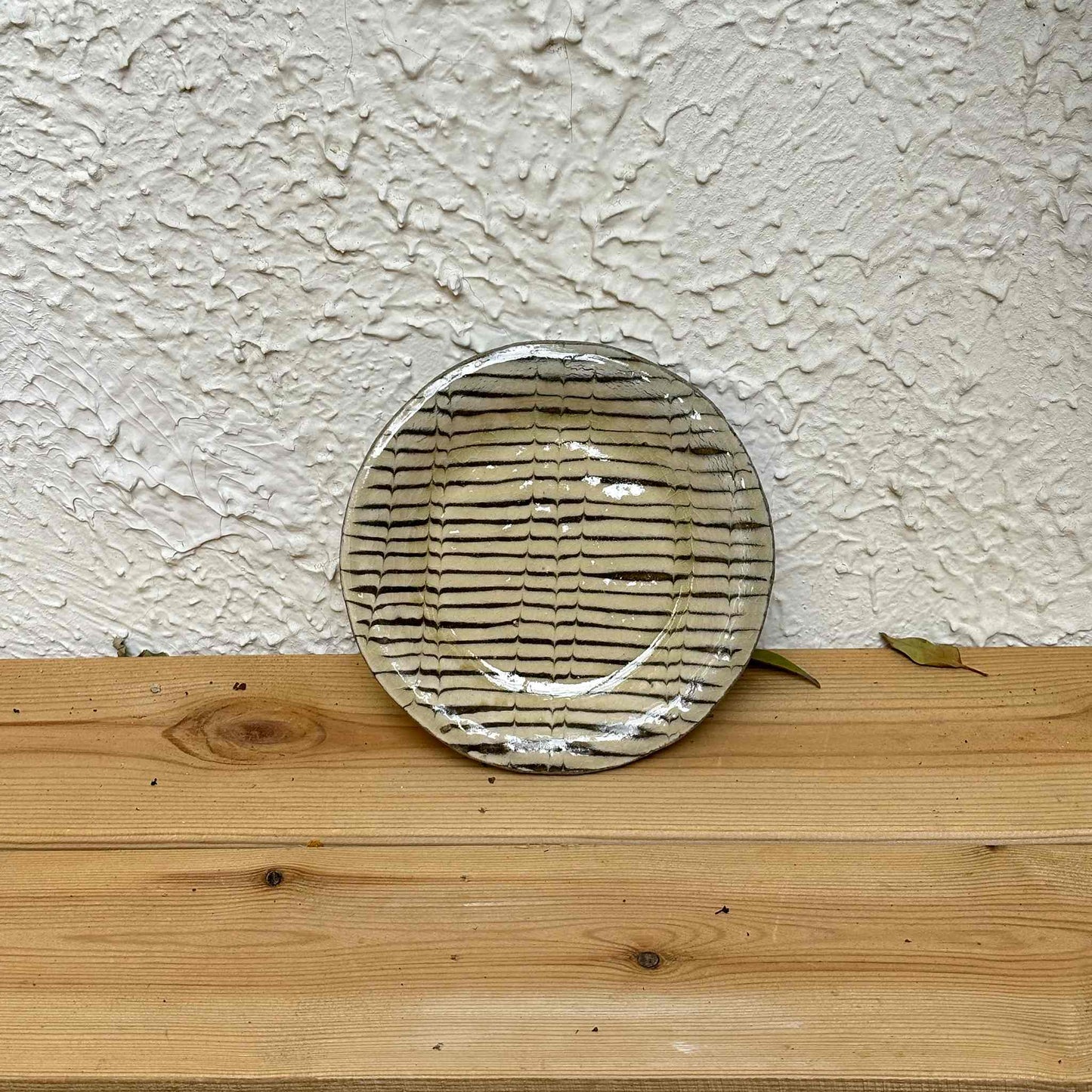 Handcrafted slipware plate by Momoko Shiohata, featuring a unique, hand-painted design on a white background.