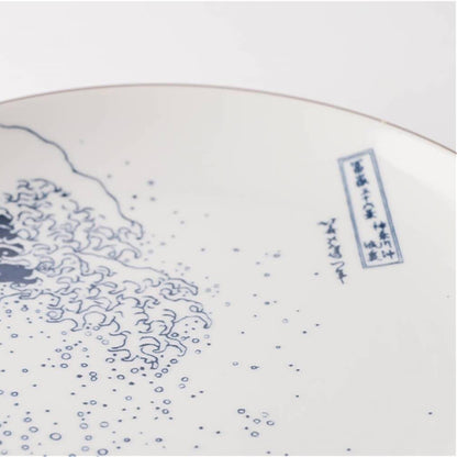 Ceramic plate with blue wave design and text on a white background