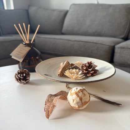 A handcrafted, shallow bowl made of ceramic, created by Japanese artisan Takashi Sogo.