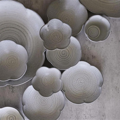 Collection of ceramic bowls with textured surfaces on a concrete surface