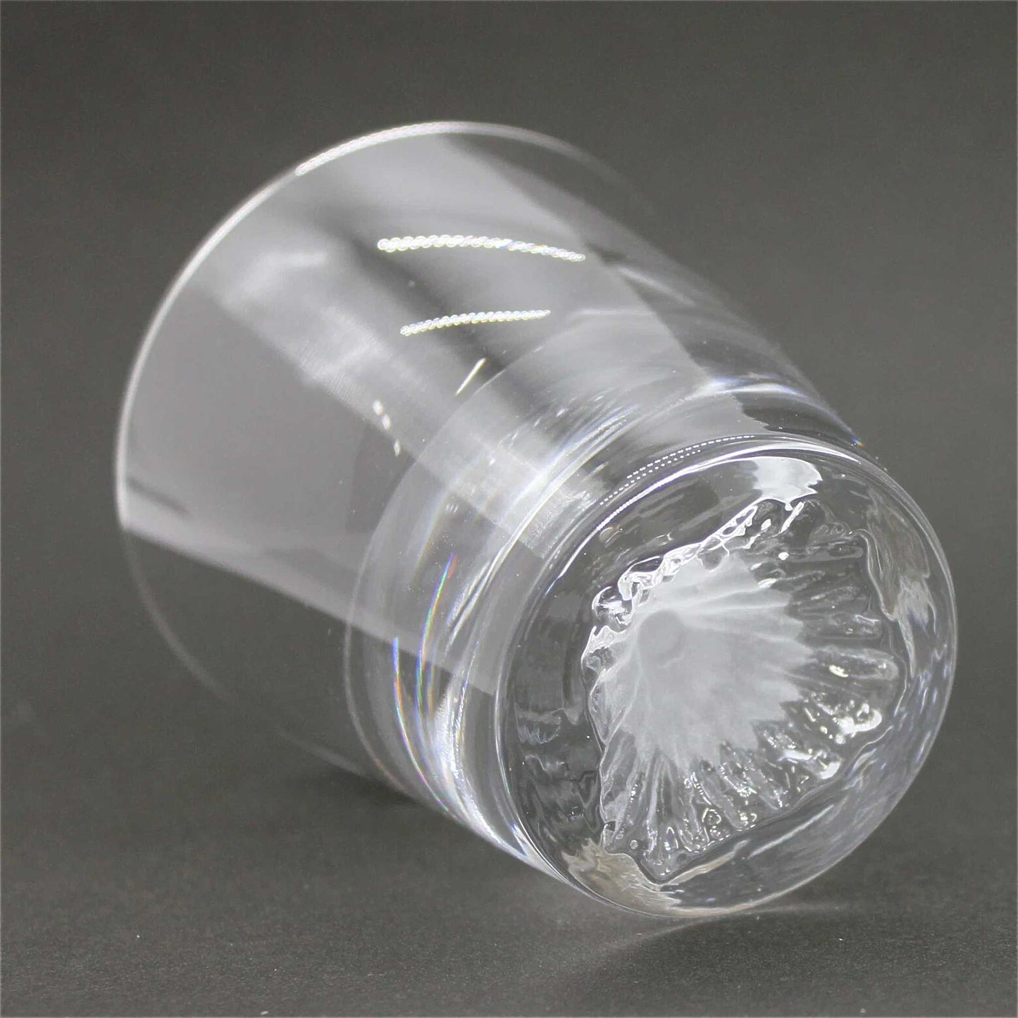 Clear glass container with a textured surface on a dark background