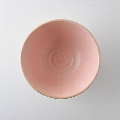 Pink ceramic bowl with a subtle pattern on a light gray background