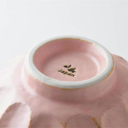 Close-up of a pink ceramic bowl with 'Japan' branding on a white background