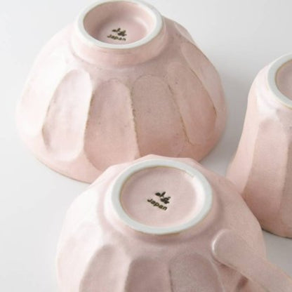 Three pink ceramic items with 'Japan' branding on a light gray background