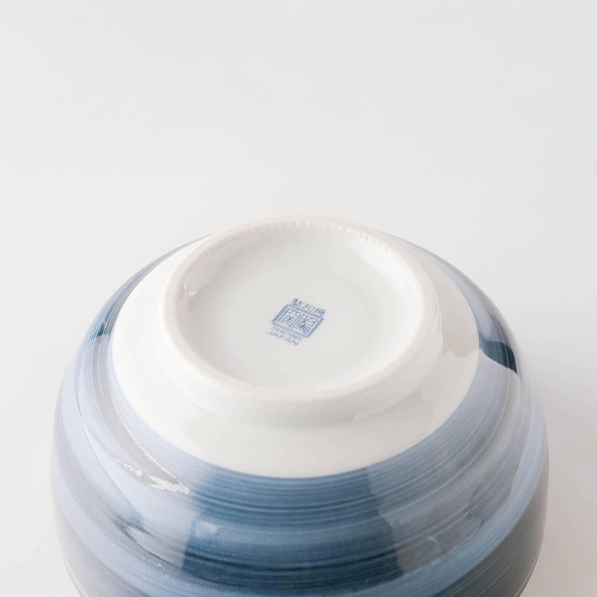 Ceramic bowl with blue and white design on a light gray background