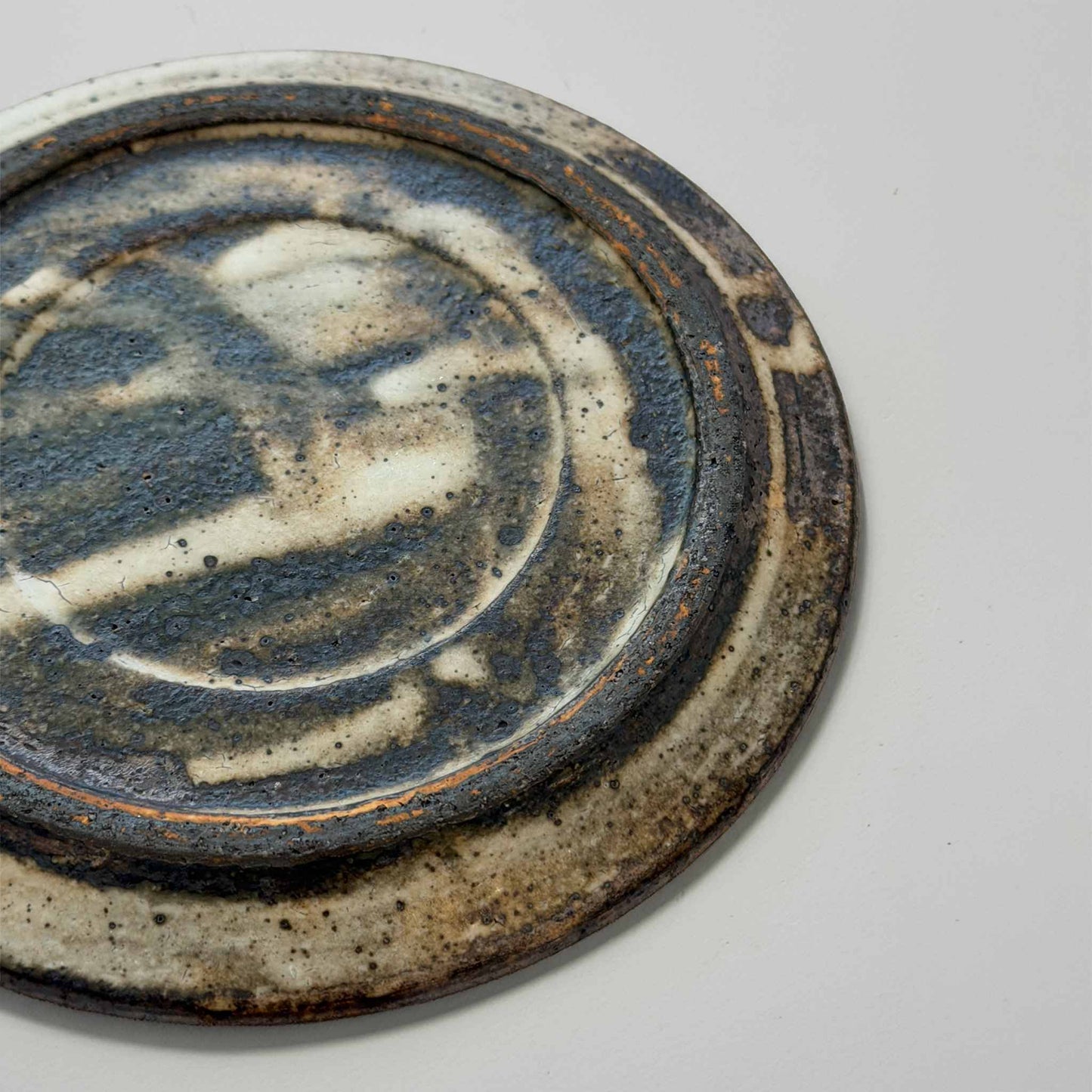 A close-up of a handmade ceramic plate, showcasing its intricate design and craftsmanship.