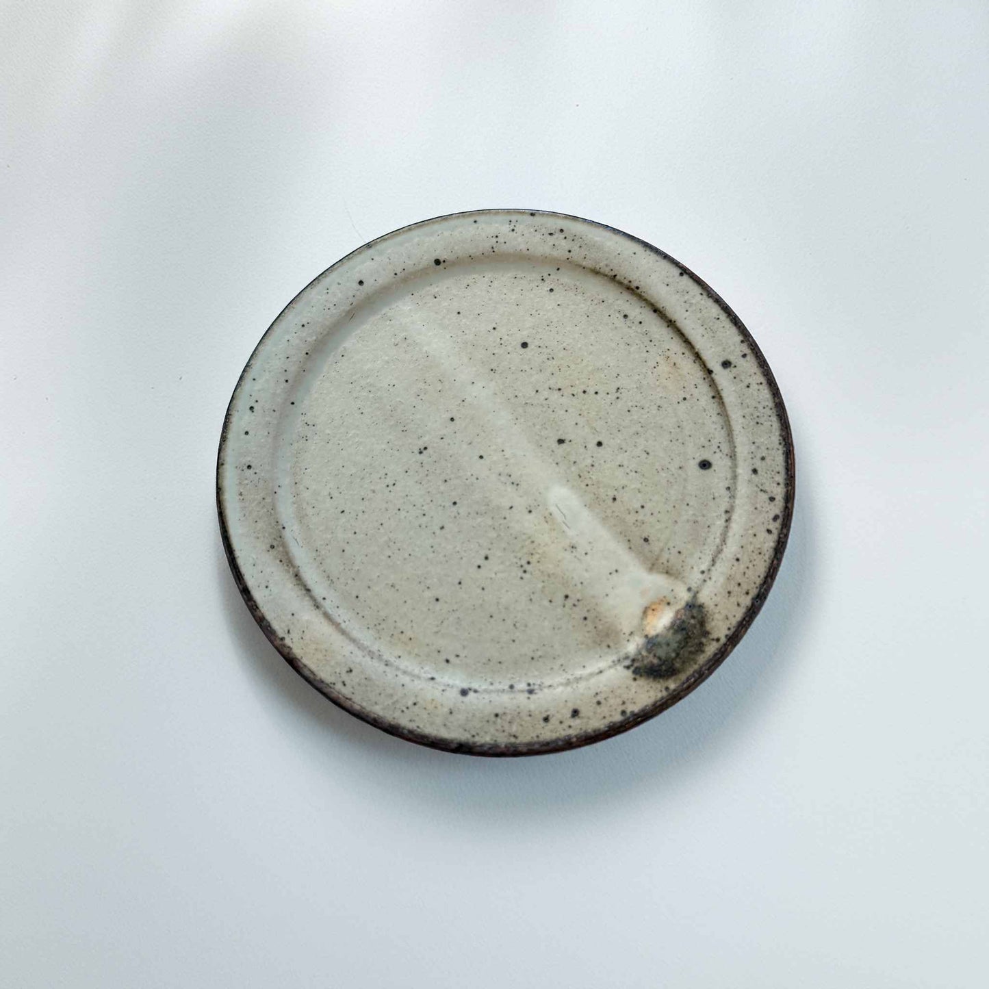 Speckled ceramic plate on a white background