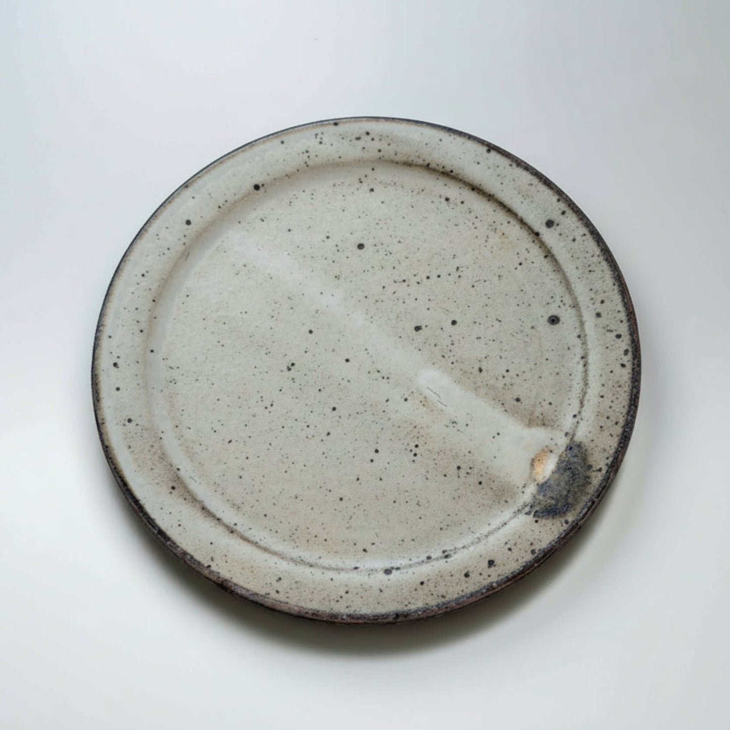 Speckled ceramic plate on a white background