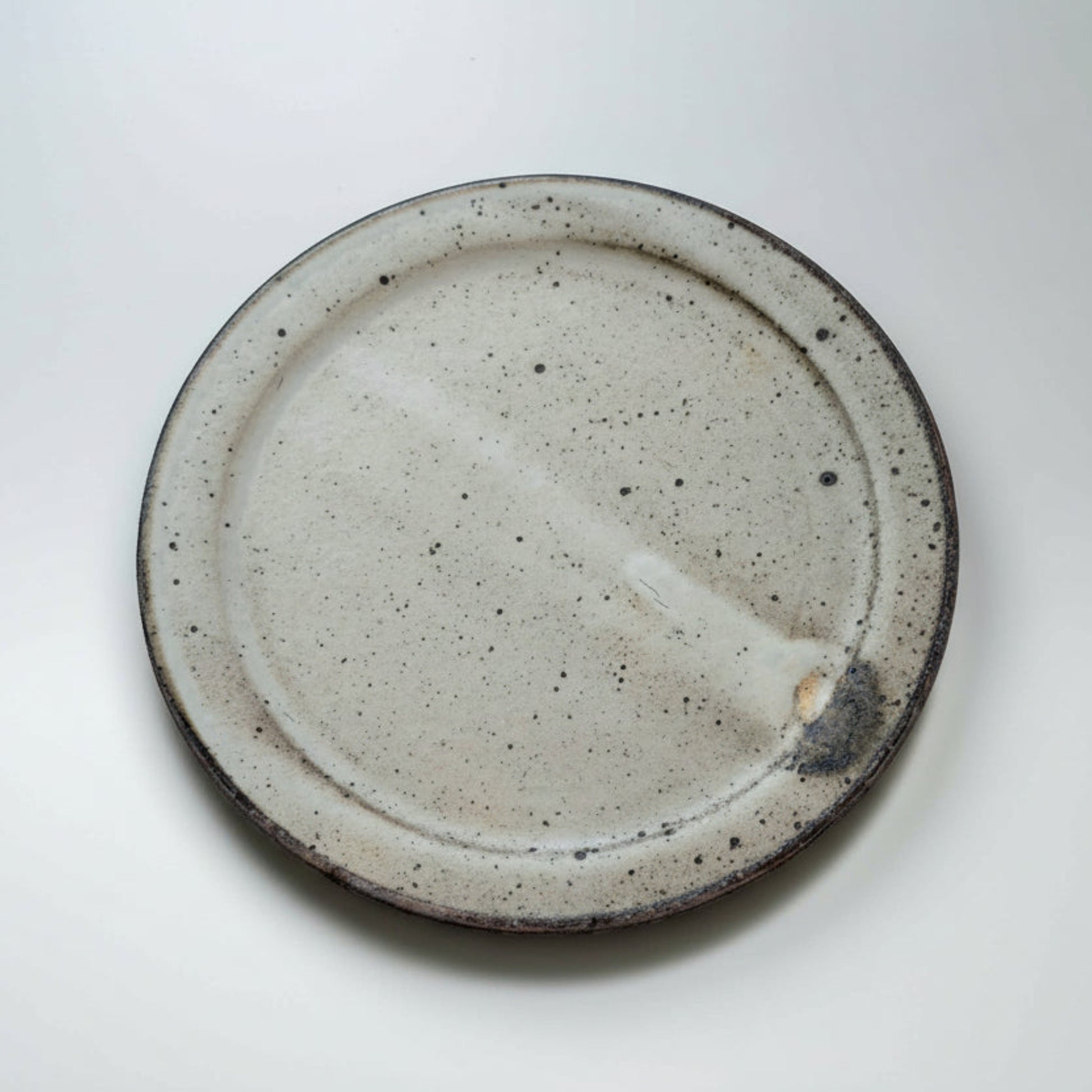 Speckled ceramic plate on a white background