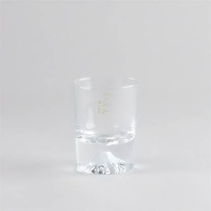 Clear glass tumbler with a gold logo on a white background