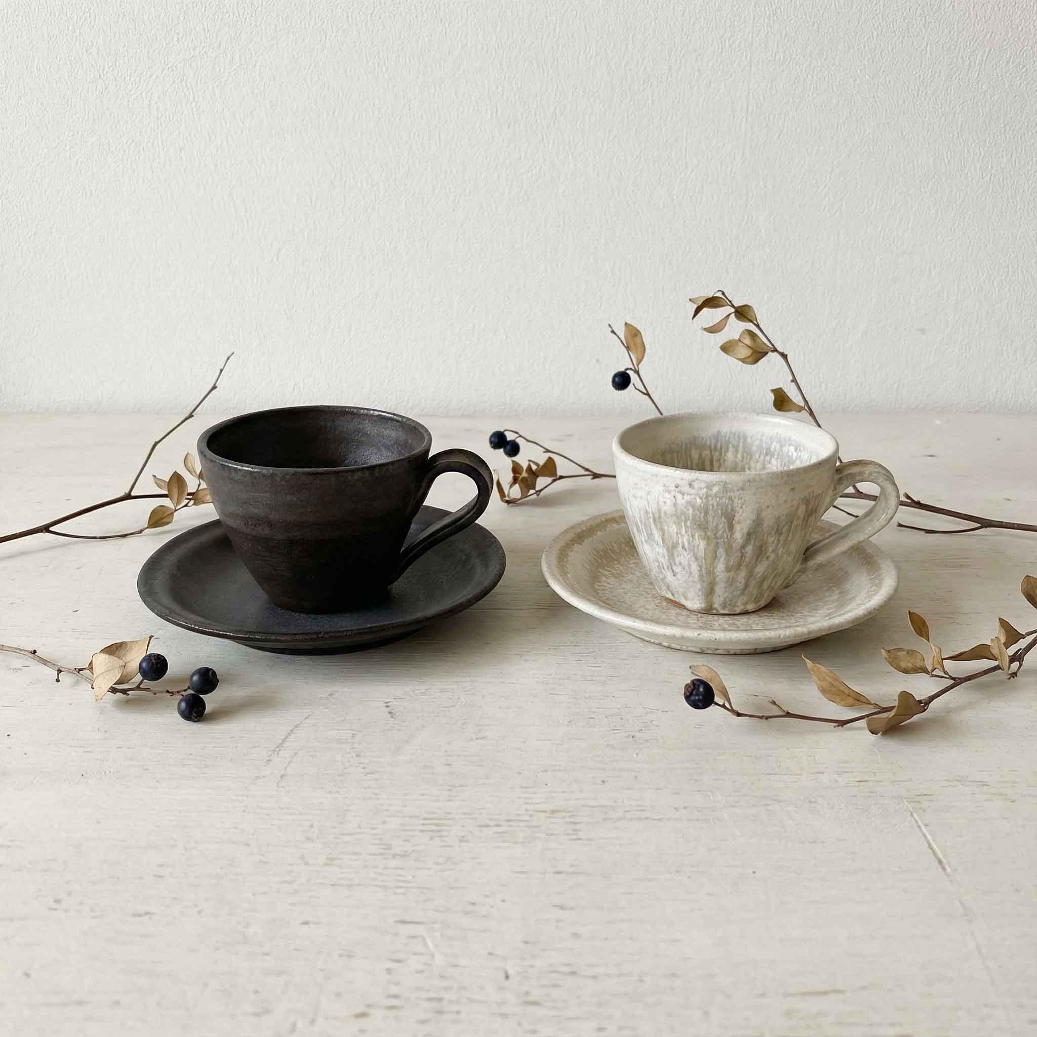 Handcrafted Kyuuko cup and saucer set in black gold and light snow glaze, evoking a sense of traditional Japanese design.