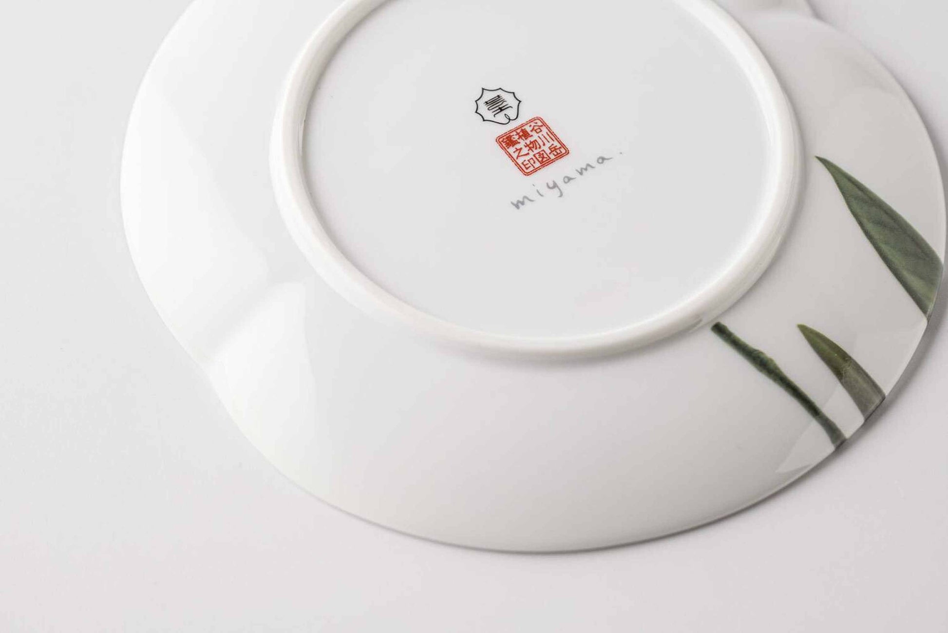 Stacked Mino ware botanical plates showing the delicate hand-painted edges.