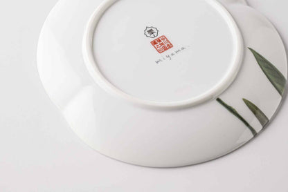 Stacked Mino ware botanical plates showing the delicate hand-painted edges.