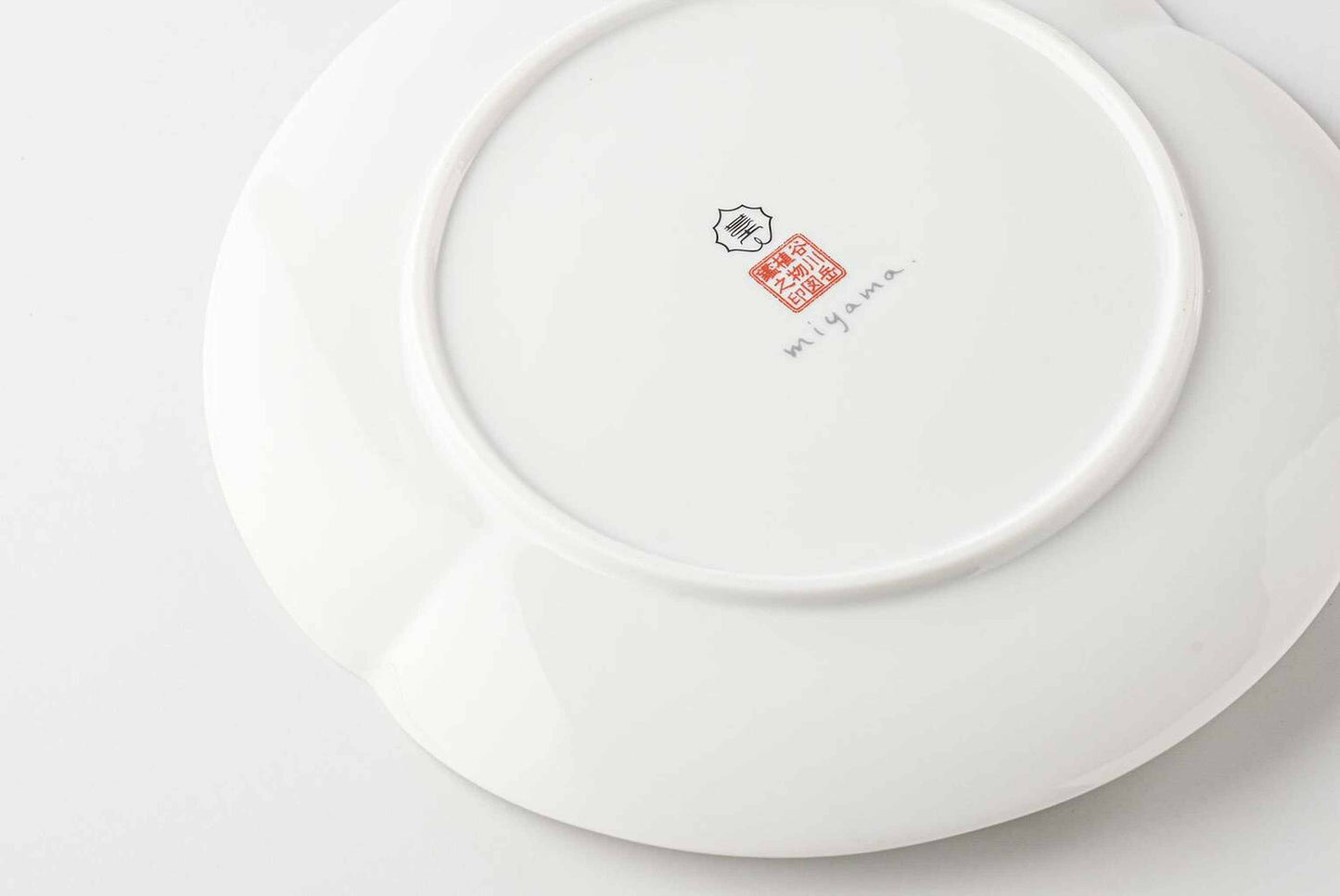 A white, delicate, and intricately designed 8-inch porcelain plate with a daisy pattern, made from Mino Ware, a traditional Japanese ceramic material.