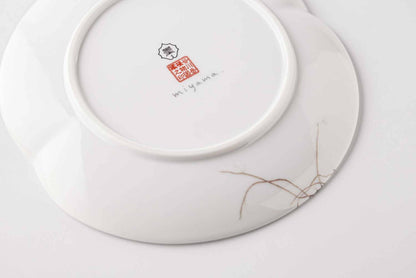 A white, delicate, and intricately designed 6-inch porcelain plate with a daisy motif, made from Mino Ware, a traditional Japanese ceramics style.