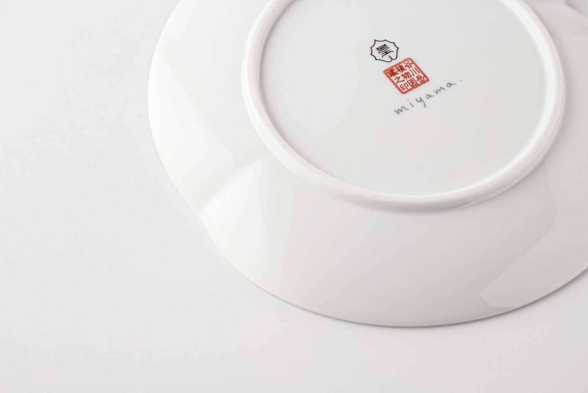 A white, delicate, and intricately designed 6-inch porcelain plate with a daisy pattern, made from Mino Ware, a type of Japanese porcelain.