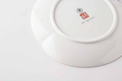 A white, delicate, and intricately designed 6-inch porcelain plate with a daisy pattern, made from Mino Ware, a type of Japanese porcelain.