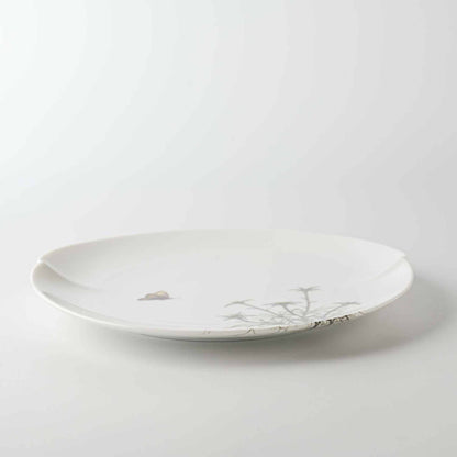 A delicate, white, hand-painted daisy patterned porcelain plate with a slightly wavy rim, set against a plain white background.