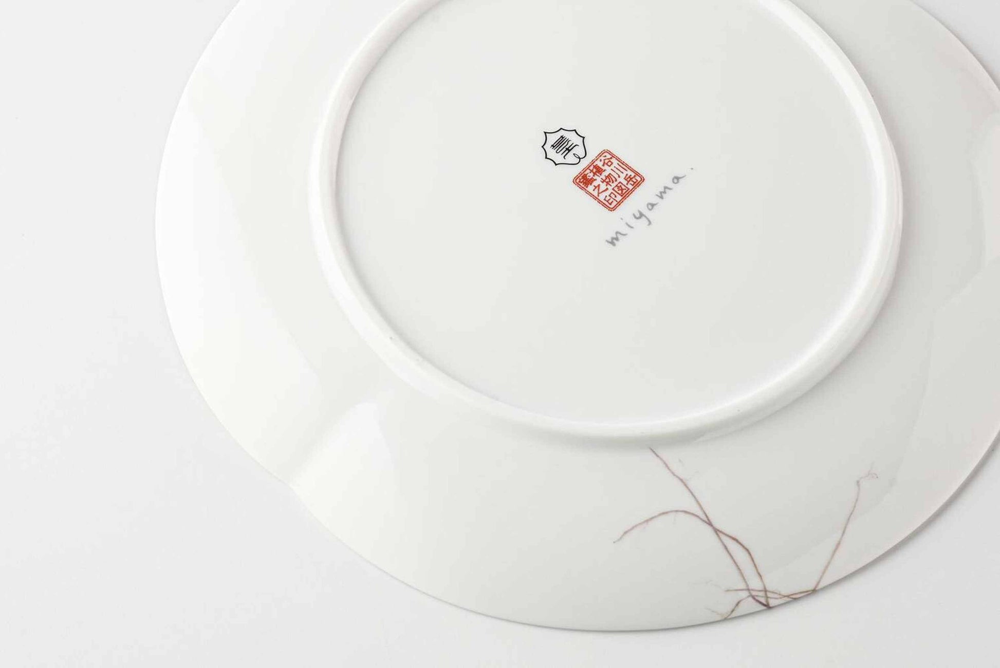 A white, delicate, and intricately designed 8-inch porcelain plate with a daisy motif, made of Mino Ware, a traditional Japanese ceramic.