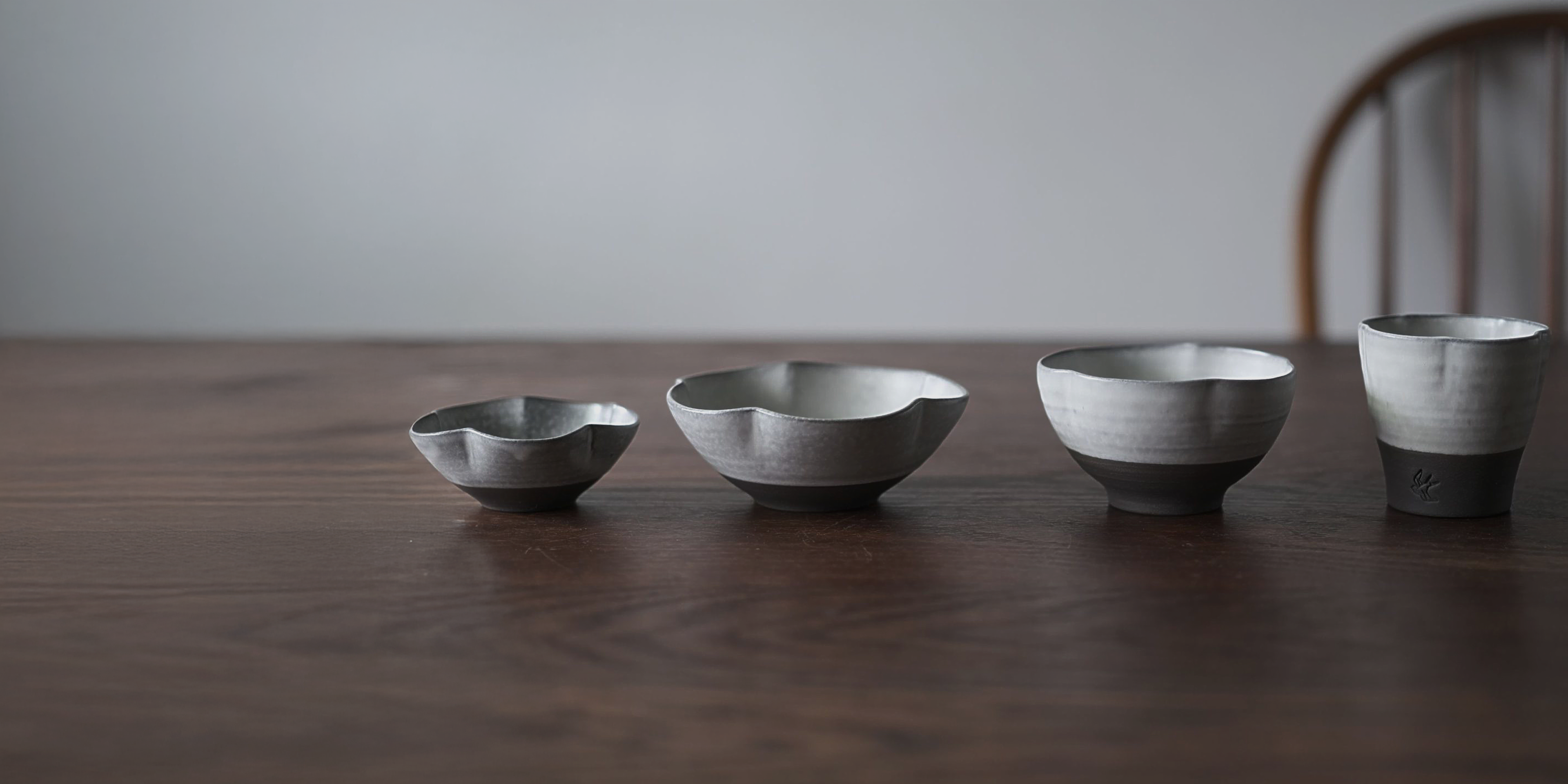 Set of four metallic bowls on a wooden surface with a neutral background